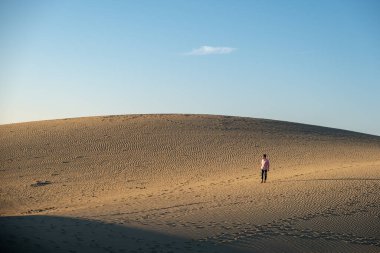 Maspalomas sahilinde yürüyen bir adam Gran Canaria İspanya 'da, Maspaloma' nın kum tepelerinde yürüyen bir adam.