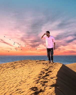 Maspalomas sahilinde yürüyen bir adam Gran Canaria İspanya 'da, Maspaloma' nın kum tepelerinde yürüyen bir adam.