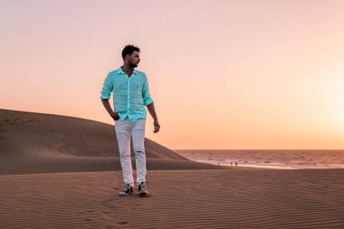 Maspalomas sahilinde yürüyen bir adam Gran Canaria İspanya 'da, Maspaloma' nın kum tepelerinde yürüyen bir adam.
