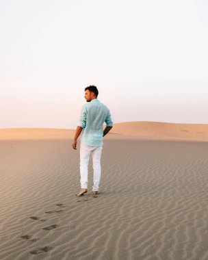 Maspalomas sahilinde yürüyen bir adam Gran Canaria İspanya 'da, Maspaloma' nın kum tepelerinde yürüyen bir adam.