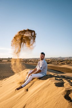 Maspalomas sahilinde yürüyen bir adam Gran Canaria İspanya 'da, Maspaloma' nın kum tepelerinde yürüyen bir adam.