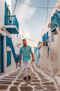 Yunanistan 'da tatil yapan gençler, Yunanistan' da Mikonos, Yunanistan 'da Küçük Venedik Mikonoları, Mykonos şehrinde okyanusta gün batımı