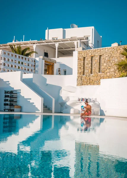 Giovani in vacanza Mykonos greece, giovane ragazzo che legge libro in piscina a Mykonos — Foto Stock