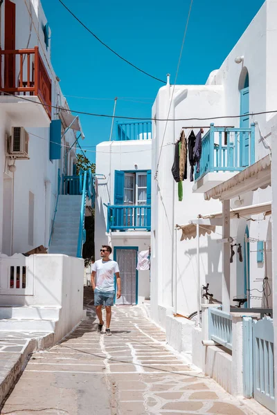 休暇中の若い男性ギリシャ,ミコノス島ギリシャ,リトルヴェネツィアミコノス島ギリシャ,ミコノス島の町で海の前で日没 — ストック写真