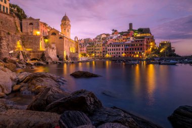 La Spezia, İtalya 'daki Cinque Terre' den Vernazza 'nın manzarası. Okyanus ötesine bakan mutlu genç çift dağda piknik yapıyor.