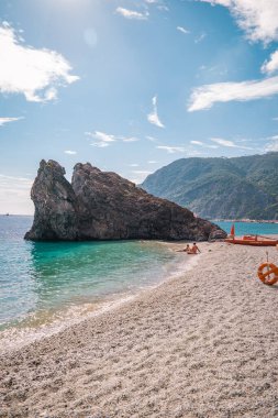 Monterosso sahilinde tatilde olan genç bir kadın Cinque Terre Monterosso al Mare çakıl taşı plajı Cinque Terre, İtalya 