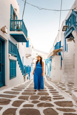 Mykonos Yunanistan 'da tatil yapan kadın, Küçük Venedik Mikonos Yunanistan, Mykonos kasabasında okyanus kenarında gün batımı