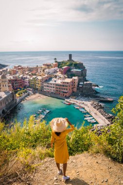La Spezia, İtalya 'daki Cinque Terre' den Vernazza 'nın manzarası. Okyanus ötesine bakan mutlu genç çift dağda piknik yapıyor.