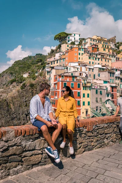 Vista de Riomaggiore uno de Cinque Terre en la provincia de La Spezia, Italia, picnic feliz pareja joven en la montaña con una mirada sobre el océano — Foto de Stock
