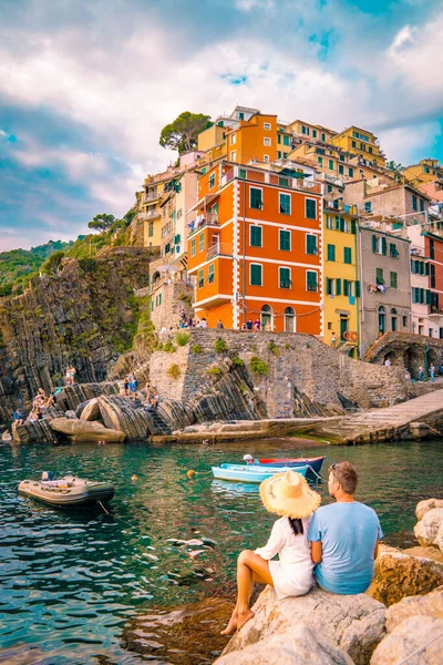 Riomaggiore Cinque Terre Itália, colorido vila porto frente ao oceano, jovem casal assistindo por do sol — Fotografia de Stock