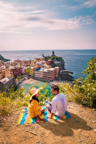 Vista de Vernazza um dos Cinque Terre na província de La Spezia, Itália, feliz piquenique casal jovem na montanha com um olhar sobre o oceano — Fotografia de Stock