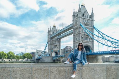 Londra 'ya şehir gezisine giden bir adam, Londra' nın ünlü yerlerinde Thames nehrinin kıyısında, Tower Köprüsü 'nde.