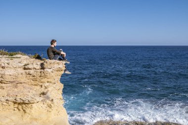 Malta Gozo, parlak bir günde Malta Gozo, Gharb 'da okyanusu izleyen genç adam.