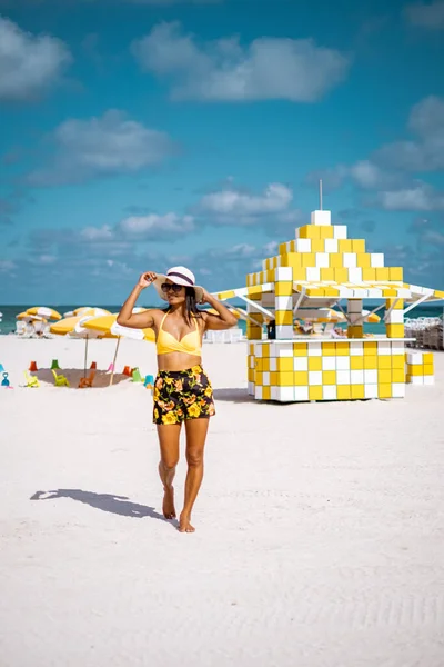 Miami beach, woman at an lifeguard hut at Miami beach Florida, girl in dress on the beach with bikini