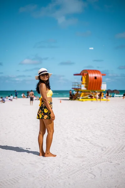 Miami beach, woman at an lifeguard hut at Miami beach Florida, girl in dress on the beach with bikini