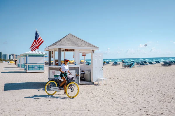 Miami Beach Florida, junge Männer am Strand mit bunter Badehütte, Mann am Strand in Miami im Urlaub — Stockfoto