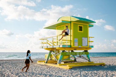 Miami Güney Sahili Florida, Sunrise Miami Sahili 'nde cankurtaran kulübesinde bir çift, plajda erkek ve kadın.