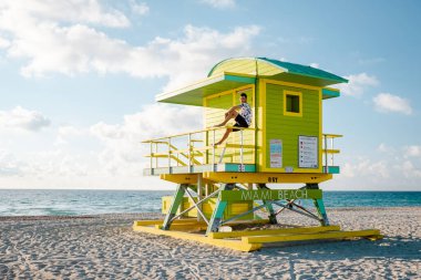 Miami Güney Sahili Florida, Sunrise Miami Sahili 'nde cankurtaran kulübesinde bir çift, plajda erkek ve kadın.