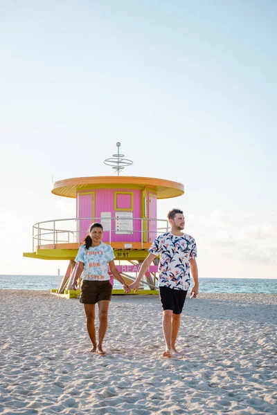 Miami south beach Florida, couple by lifeguard hut during Sunrise Miami Beach, men and woman on the beach — Stock Photo, Image