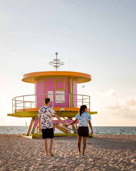 Miami south beach Florida, couple by lifeguard hut during Sunrise Miami Beach, men and woman on the beach — Stock Photo, Image