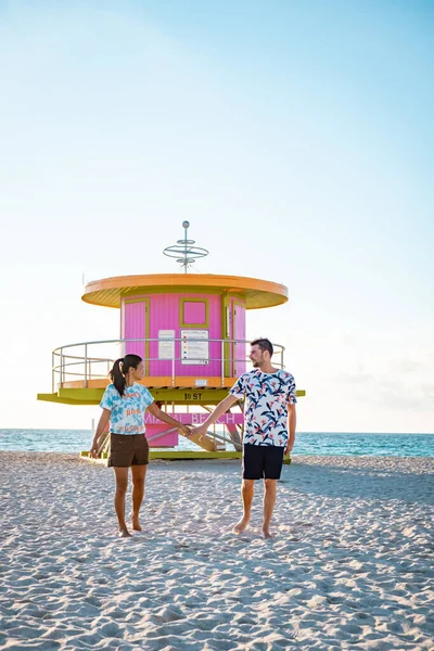 Miami south beach Florida, couple by lifeguard hut during Sunrise Miami Beach, men and woman on the beach — Stock Photo, Image