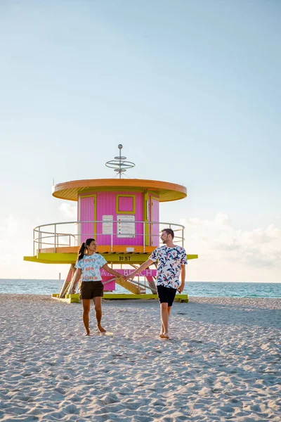 Miami south beach Florida, couple by lifeguard hut during Sunrise Miami Beach, men and woman on the beach — Stock Photo, Image