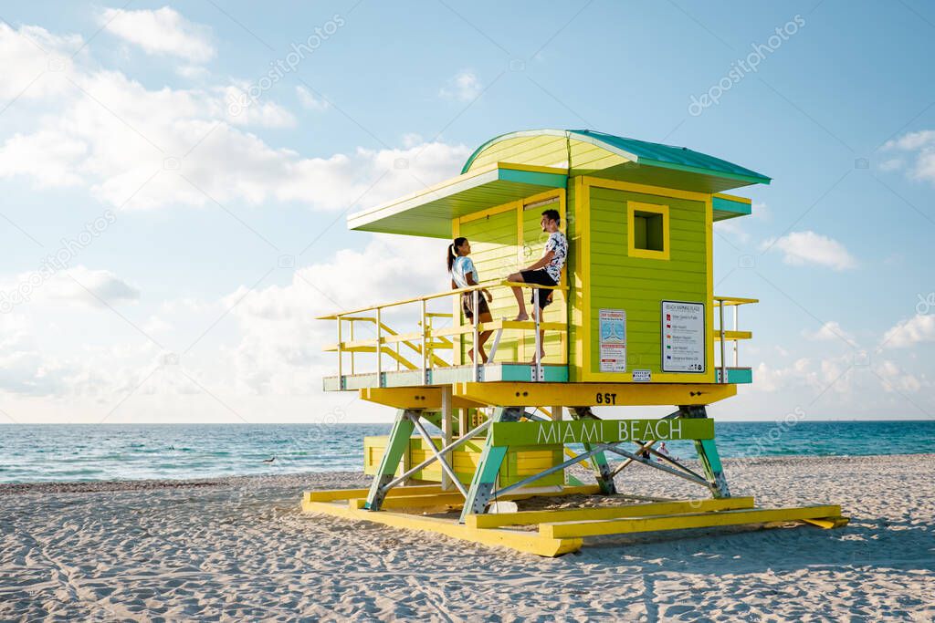 Miami south beach Florida, couple by lifeguard hut during Sunrise Miami Beach, men and woman on the beach