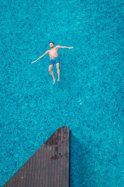 Άνδρες στην πισίνα, τύπος σε μπλε κολύμπι σύντομη από ψηλά στην πισίνα, drone θέα από ψηλά — Φωτογραφία Αρχείου