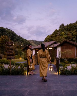 Chiang Mai, kaplıcada dinlenen genç bir çift, Onse ahşap banyo küveti, Chiang Mai Tayland 'daki kaplıcalarda banyo.