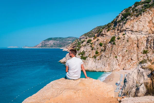 Kaputas Beach Kas indyk, biała pomarańczowa plaża z klifów nad oceanem rzeki Kas Turcja, mężczyźni stojący na klifie patrzący na ocean — Zdjęcie stockowe