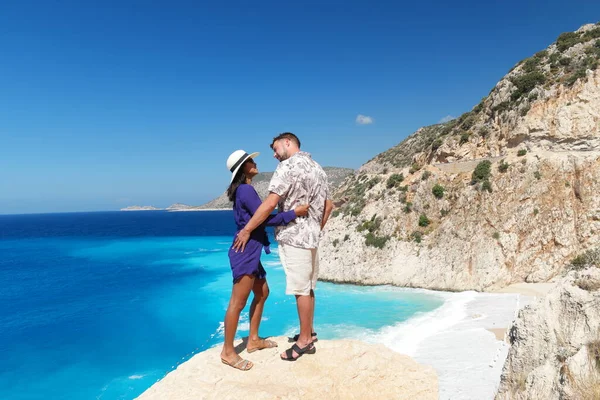 Pár na dovolené Turecko, Kaputas Beach Kas krocan, bílá pomerančová pláž z clifs u oceánu řeky Kas Turkey, muži a žena stojící na útesu hledící na oceán — Stock fotografie