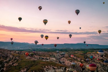 Kapadokya Türkiye tepelerde sıcak hava balonlarıyla, Kapadokya 'da gün doğumunda Kapadokya' da güneş ışığı altında güzel renkli balonlar.