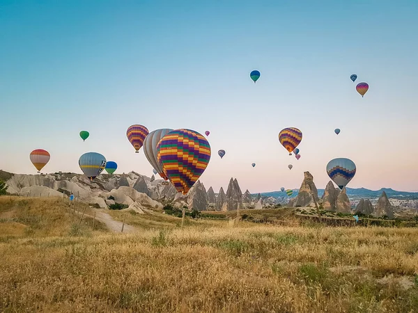 Kapadokya Türkiye tepelerde sıcak hava balonlarıyla, Kapadokya 'da gün doğumunda Kapadokya' da güneş ışığı altında güzel renkli balonlar. — Stok fotoğraf