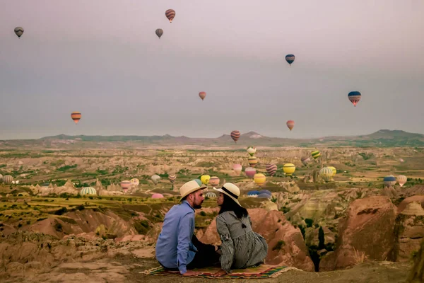 カッパドキアトルコ日の出の間に、カッパドキアの丘で休暇中のカップルの中年男性と女性トルコ、男性と女性はカッパドキアで熱気球で日の出を見て — ストック写真