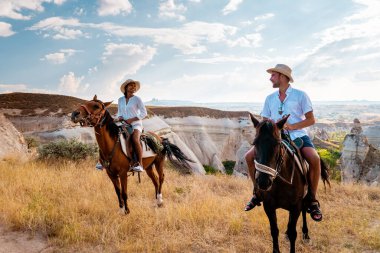 Türkiye 'de tatil yapan genç erkek ve kadın Kapadokya, Türkiye' de tatil yapan çift Kapadokya 'nın sıcak hava balonlarını izliyor