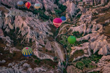 Kapadokya Türkiye tepelerde sıcak hava balonlarıyla, Kapadokya 'da gün doğumunda Kapadokya' da güneş ışığı altında güzel renkli balonlar.