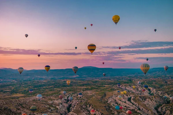 Cappadocia土耳其日出在山上用热气球，Kapadokya美丽的五彩缤纷的气球在日出阳光下在Cappadocia土耳其 — 图库照片