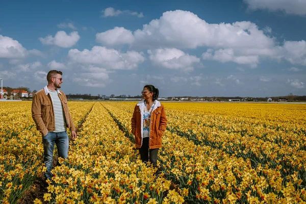 Coppia che cammina in aiuola gialla, uomini e donne in narcisi gialli durante la primavera in Olanda Lisse — Foto Stock