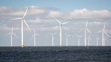 Okyanus açıklarındaki yel değirmeni çiftliği Westermeerwind Parkı 'ndaki yel değirmenleri Hollanda Flevoland Noordoostpolder' ın güneşli bir gününde denizde izole edilmiş.