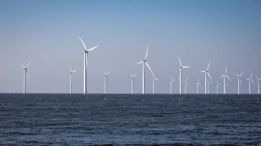 Okyanus açıklarındaki yel değirmeni çiftliği Westermeerwind Parkı 'ndaki yel değirmenleri Hollanda Flevoland Noordoostpolder' ın güneşli bir gününde denizde izole edilmiş.