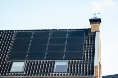 Hollanda 'da güneş panelleri çatıda güneşli bir gökyüzüne bağlı yeni evler inşa edildi. Siyah güneş panellerini kapatın.