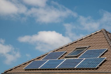 Hollanda 'da güneş panelleri çatıda güneşli bir gökyüzüne bağlı yeni evler inşa edildi. Siyah güneş panellerini kapatın.