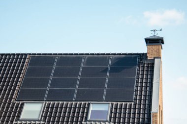 Hollanda 'da güneş panelleri çatıda güneşli bir gökyüzüne bağlı yeni evler inşa edildi. Siyah güneş panellerini kapatın.