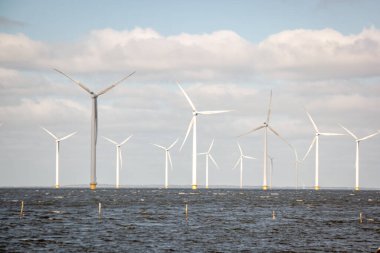 Okyanus açıklarındaki yel değirmeni çiftliği Westermeerwind Parkı 'ndaki yel değirmenleri Hollanda Flevoland Noordoostpolder' ın güneşli bir gününde denizde izole edilmiş.