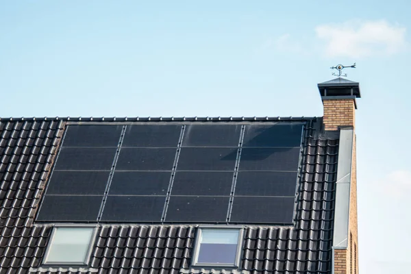 Case di nuova costruzione nei Paesi Bassi con pannelli solari attaccati sul tetto contro un cielo soleggiato Close up of new building black solar panels — Foto Stock