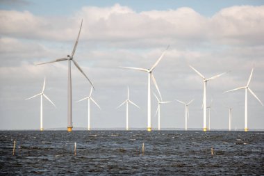 Okyanus açıklarındaki yel değirmeni çiftliği Westermeerwind Parkı 'ndaki yel değirmenleri Hollanda Flevoland Noordoostpolder' ın güneşli bir gününde denizde izole edilmiş.