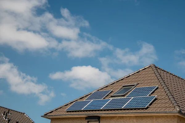 Case di nuova costruzione nei Paesi Bassi con pannelli solari attaccati sul tetto contro un cielo soleggiato Close up of new building black solar panels — Foto Stock