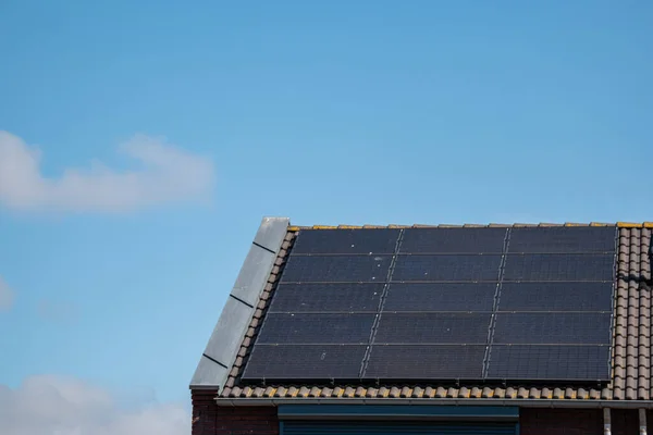 Case di nuova costruzione nei Paesi Bassi con pannelli solari attaccati sul tetto contro un cielo soleggiato Close up of new building black solar panels — Foto Stock