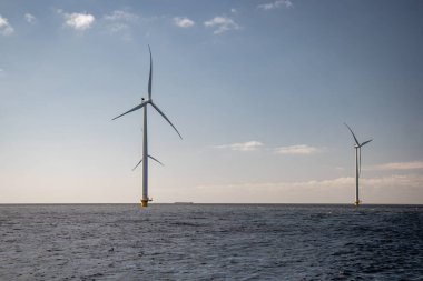 Okyanus açıklarındaki yel değirmeni çiftliği Westermeerwind Parkı 'ndaki yel değirmenleri Hollanda Flevoland Noordoostpolder' ın güneşli bir gününde denizde izole edilmiş.