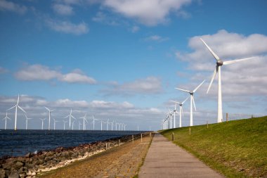 Okyanus açıklarındaki yel değirmeni çiftliği Westermeerwind Parkı 'ndaki yel değirmenleri Hollanda Flevoland Noordoostpolder' ın güneşli bir gününde denizde izole edilmiş.